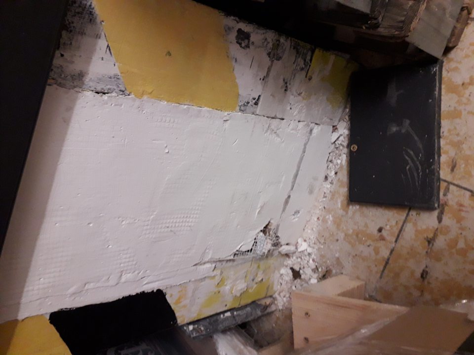 narušená celistvosť steny pri paletách s uloženým tovarom v zázemí skladu