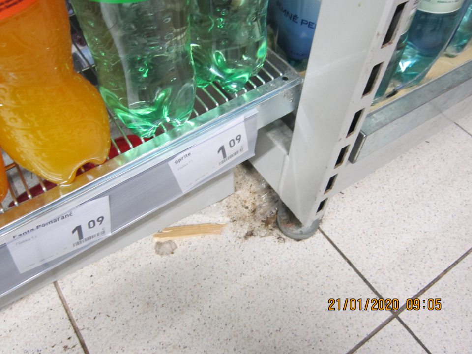 Na predajnej ploche na úseku predaja nápojov znečistená podlaha okolo stojanov na regály.  