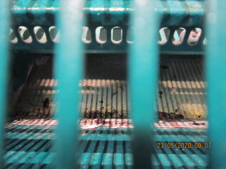 Znečistený priestor pod mriežkou v chladiacom zariadení na predajnej ploche.