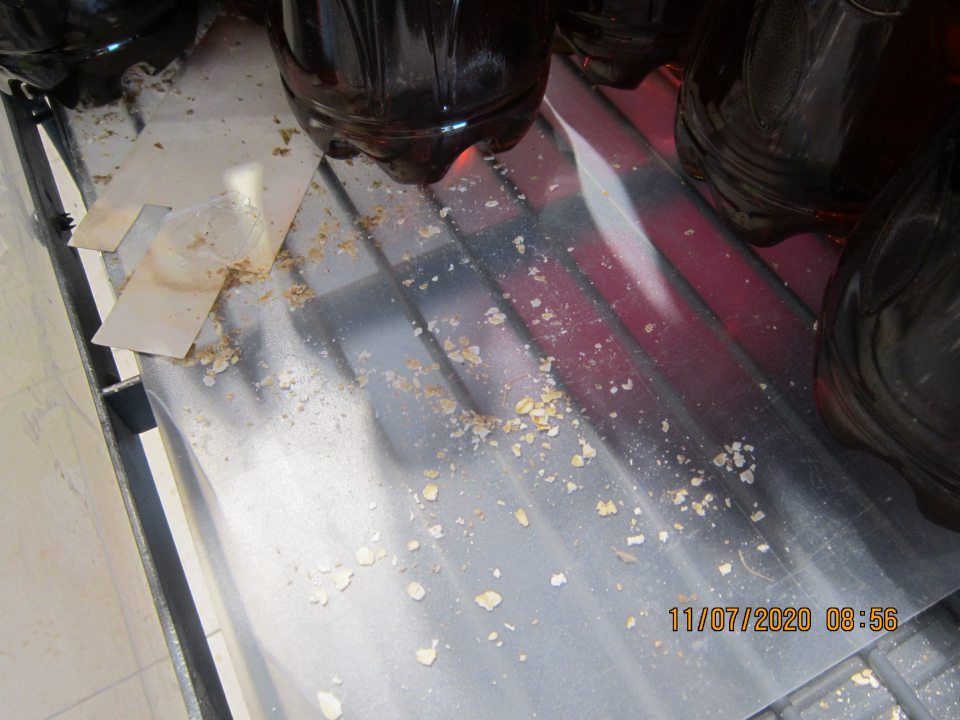 Na predajnej ploche regál znečistený nečistotami, zvyškom z kartónu. 