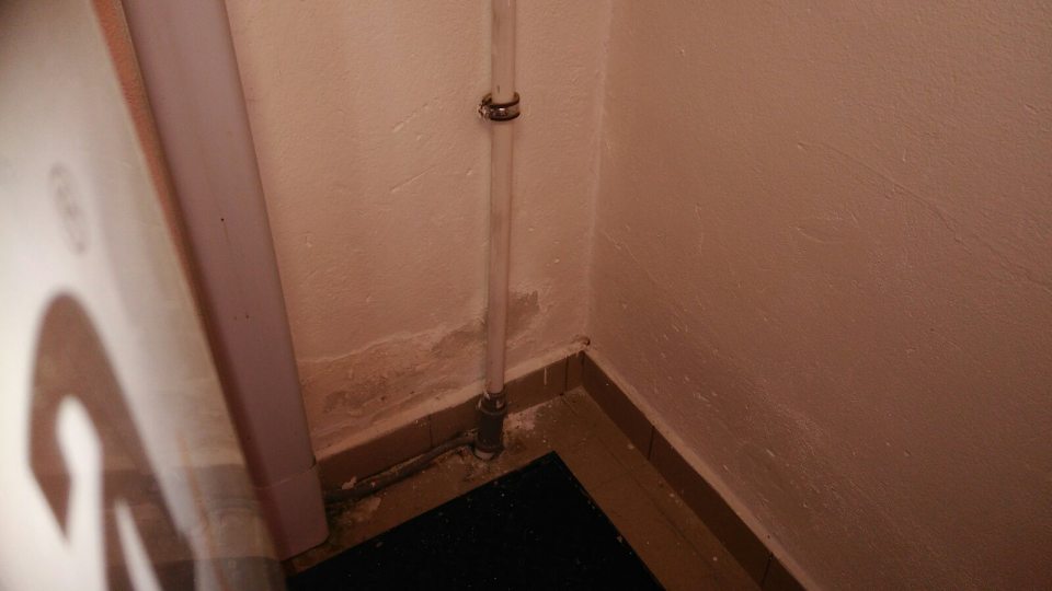 Poškodená a olupujúca sa omietka steny v predajni pri chladiacom boxe mäsových výrobkov