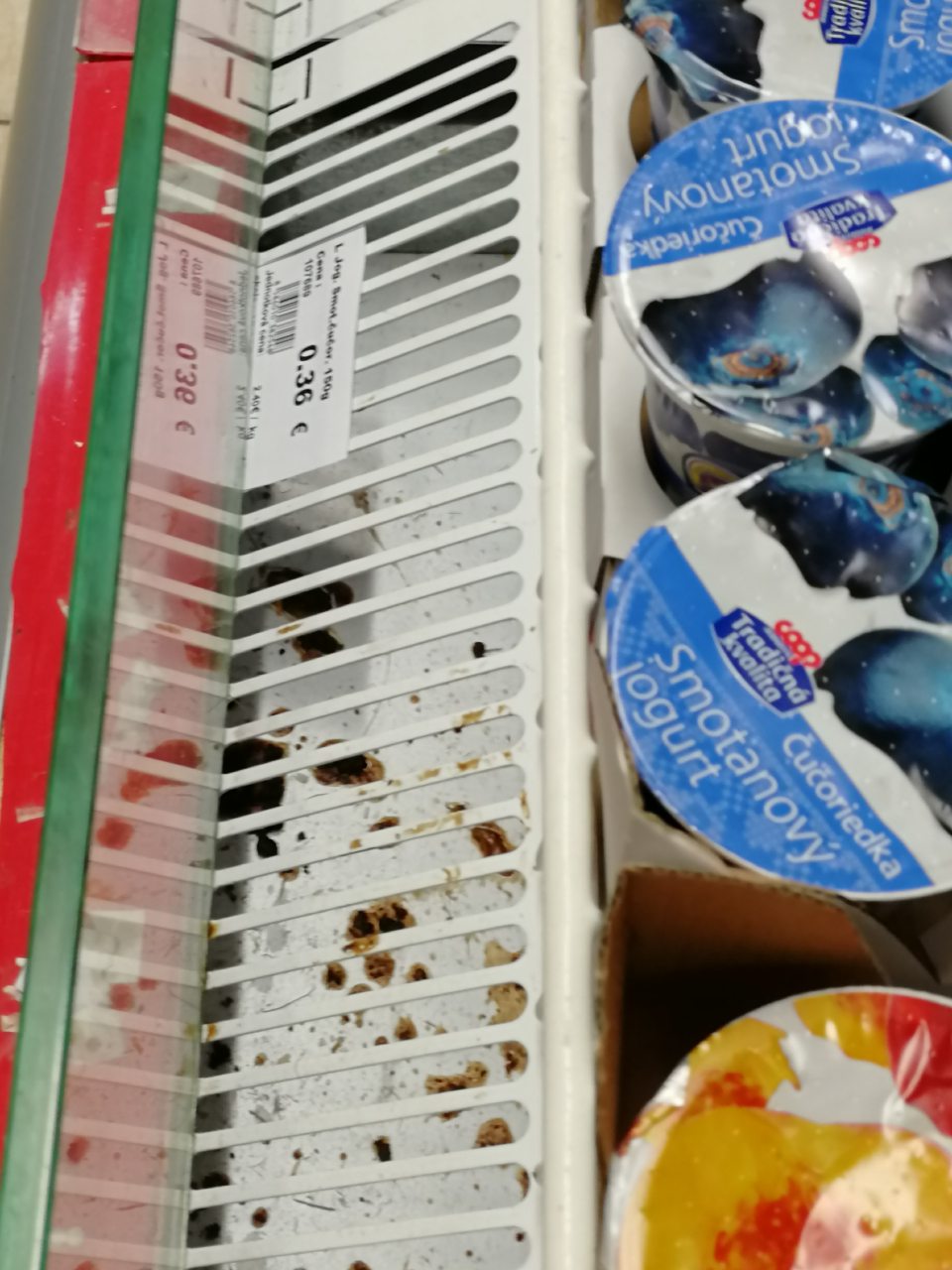 Znečistená mriežka v chladiacej vitríne s mliečnymi výrobkami.