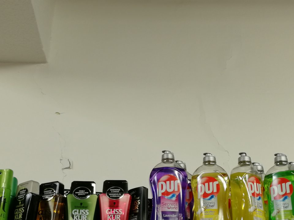 Popraskaná, opadávajúca omietka stien v časti predaja drogistického tovaru.