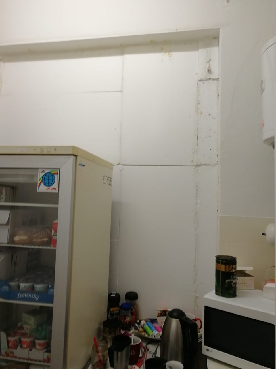 Nedokončená úprava povrchu steny po výplni bývalých okien (obnažený polystyrén) v kuchynke zamestnancov.