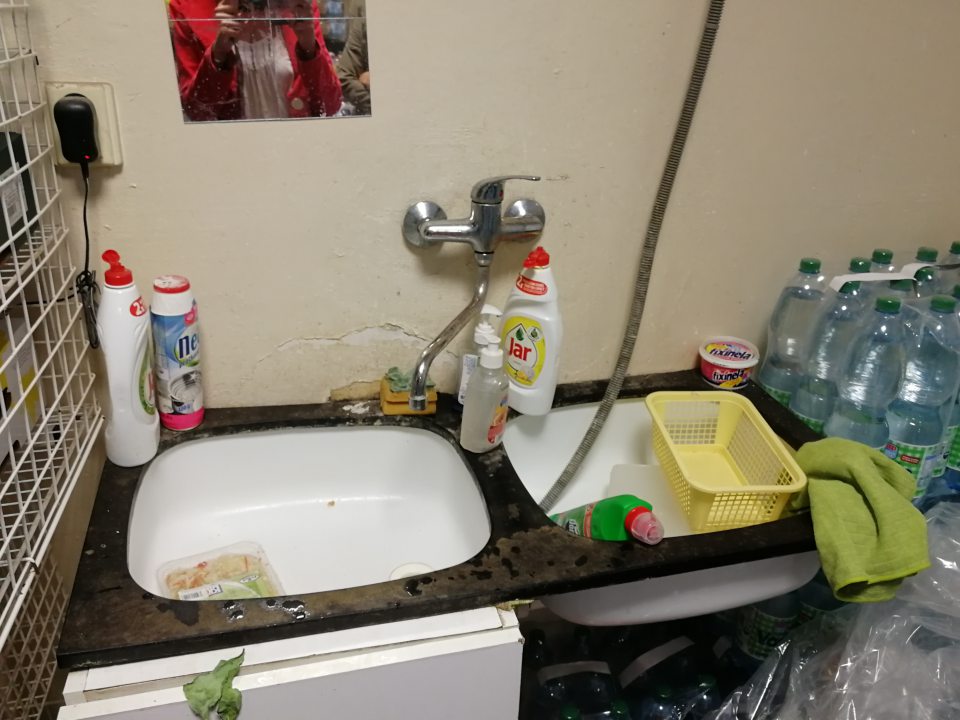 Poškodená, olupujúca sa omietka v okolí umývadla s počiatočným výskytom čiernej plesne.