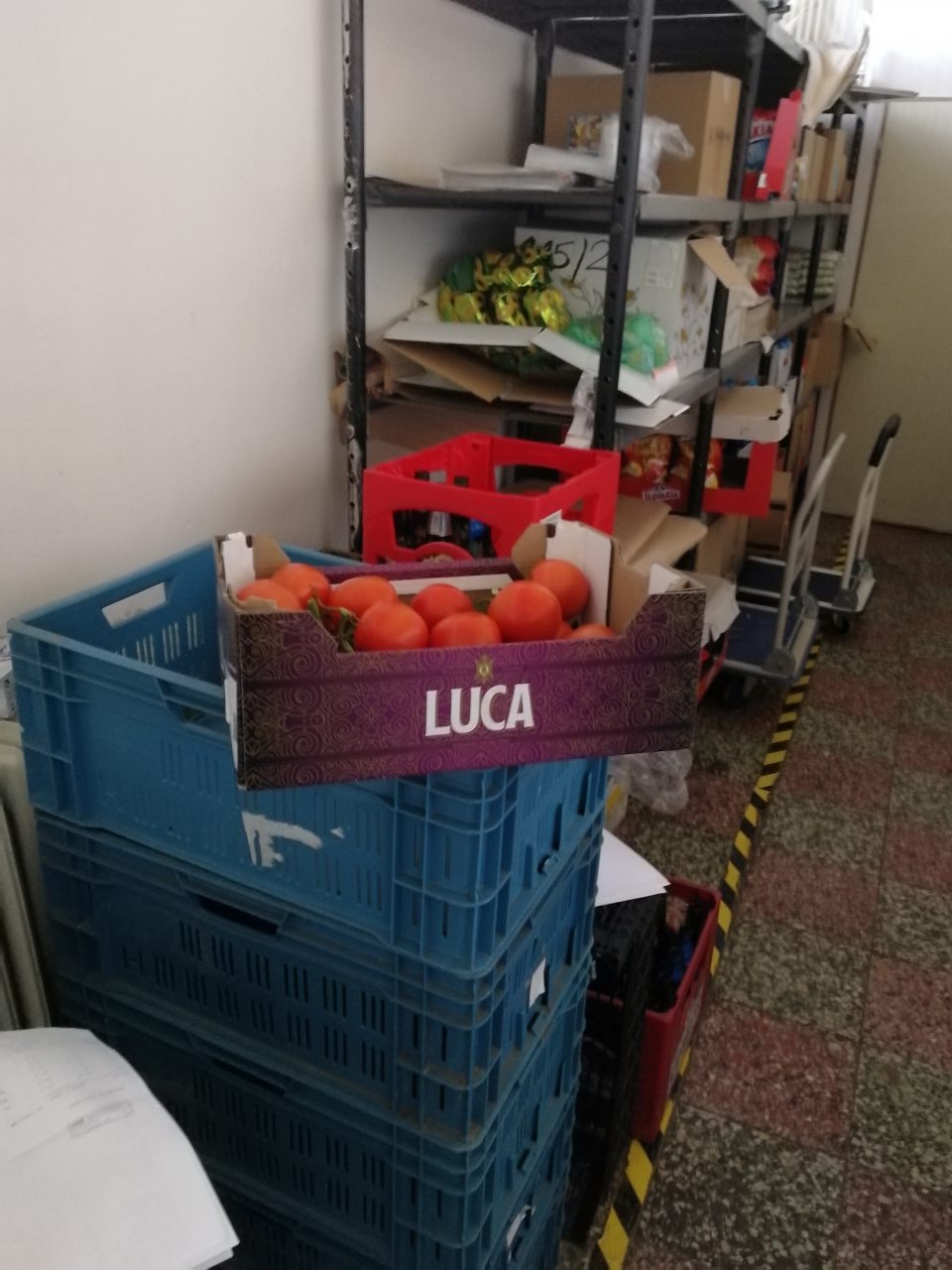 V priestoroch skladu sú potraviny, rôzne predmety, kartóny uložené chaoticky a neusporiadane.