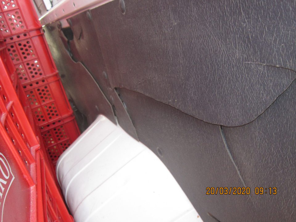 Zadné dvere dopravného prostriedku z vnútornej strany poškodené - čierna plastová výplň poškodená, prasknutá. Čierna plastová výplň taktiež poškodená na bočnej stene dopravného prostriedku z vnútornej strany - riziko kontaminácie úlomkami