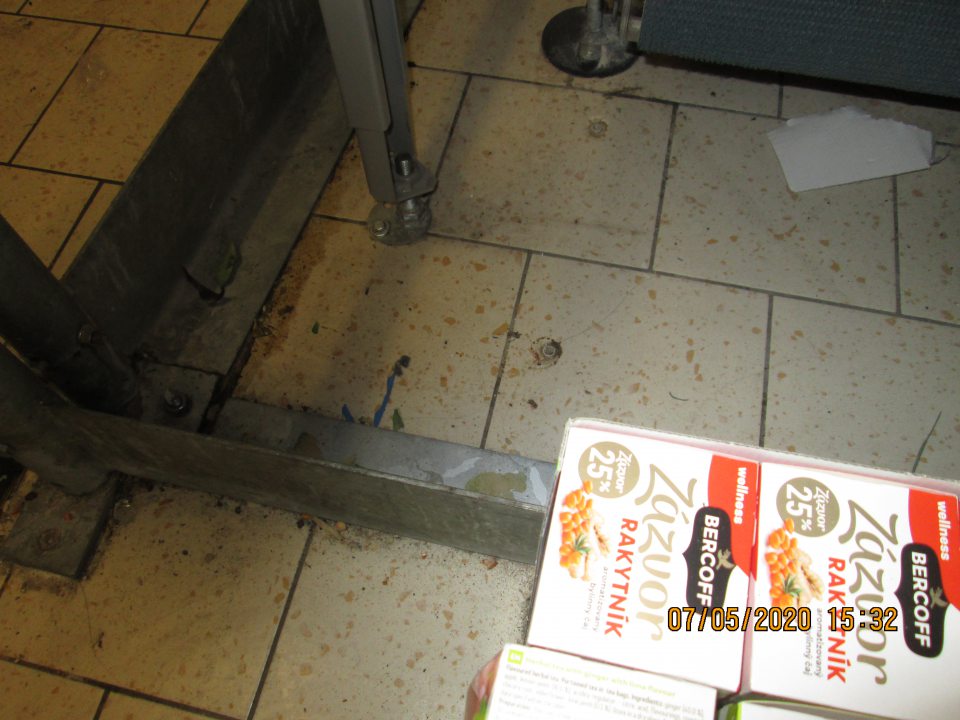 V sklade po okraji spodnej konštrukcie lisu znečistená podlaha, na ktorej priamo na podlahe v kartónovej krabici boli uložené zázvorové čaje. 