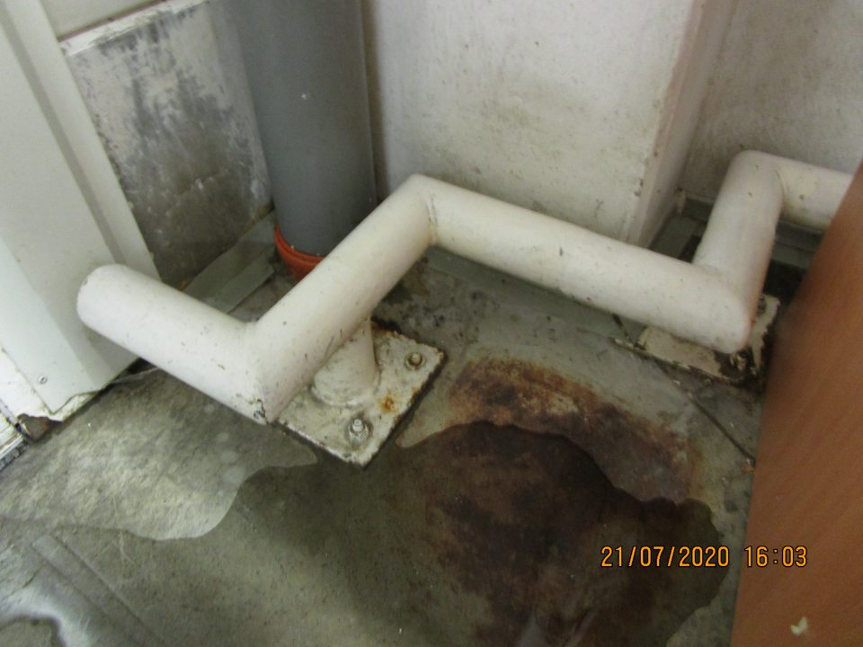 v zázemí prevádzky pri mraziacom boxe s uskladnenými hlbokozmrazenými potravinami opadaná omietka steny na troch miestach a znečistená podlaha 