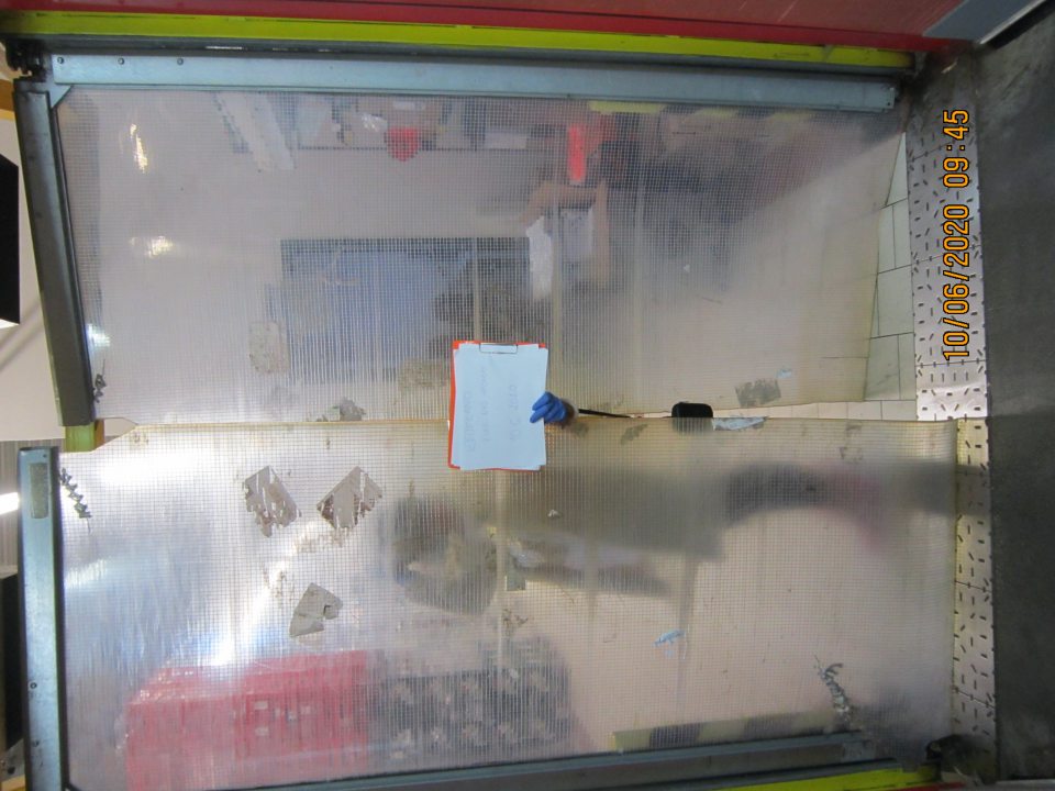 Poškodené a znečistené predeľovacie dvere medzi prijímovou rampou a centrálnym skladom. 