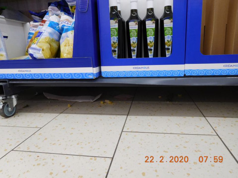 Podlaha v predajni znečistená prachom, zvyškami potravín, kartónových obalov a fólií.