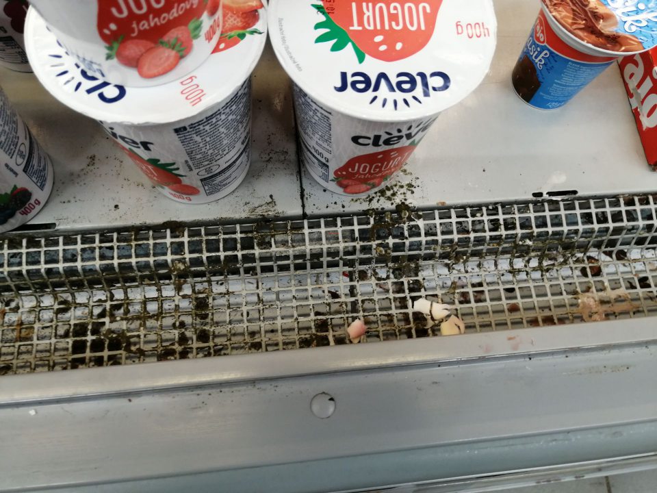 Znečistená spodná polica, mriežka a priestor pod mriežkou s výskytom plesne v chladiacom zariadení na predajnej ploche.