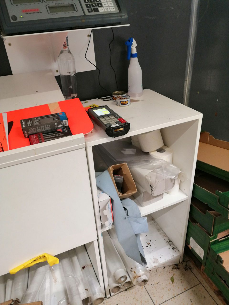 Znečistená podlaha v okolí priestoru skladníka a nános nečistôt v policiach.