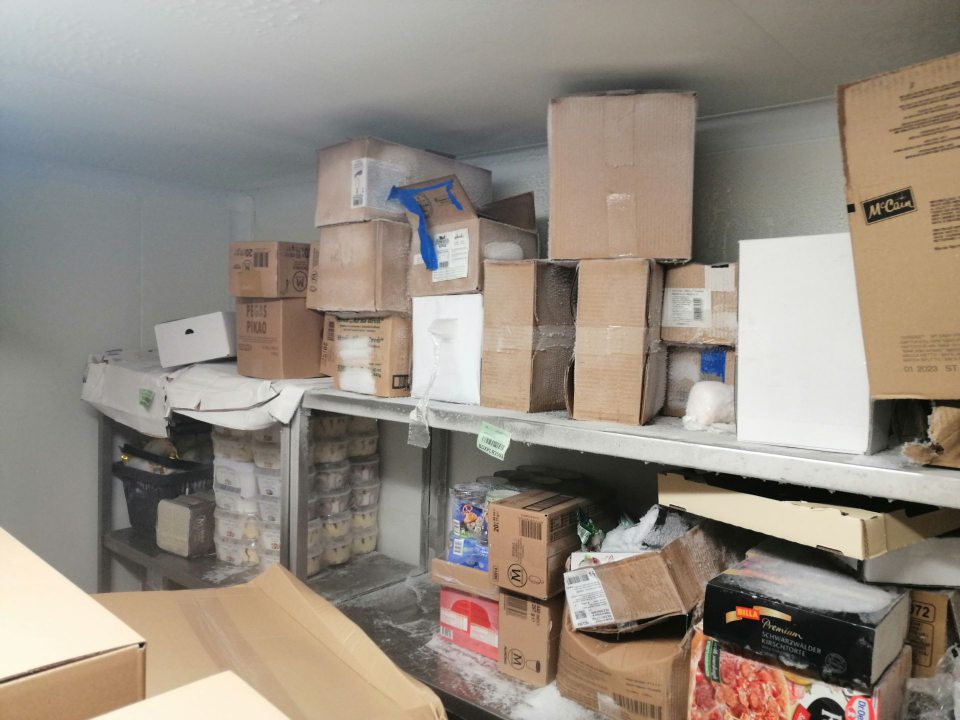 Námraz na strope, regáloch a krabiciach s tovarom v mraziarenskom sklade.