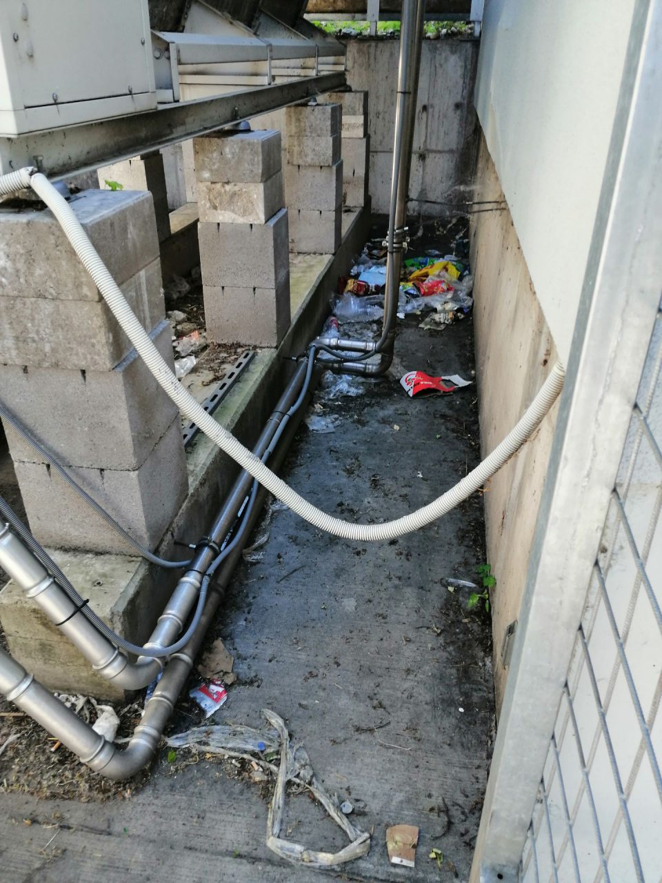 Nános nečistôt a odpadkov v klietke s chladiacimi jednotkami.