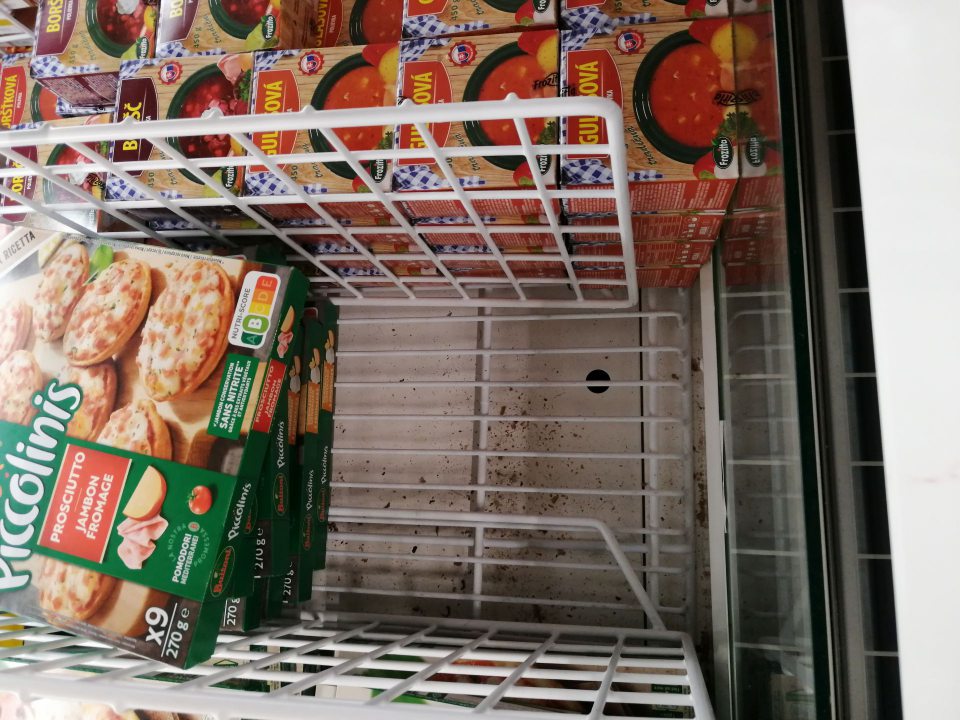 Nános nečistôt na dne mraziacej vane na predajnej ploche.