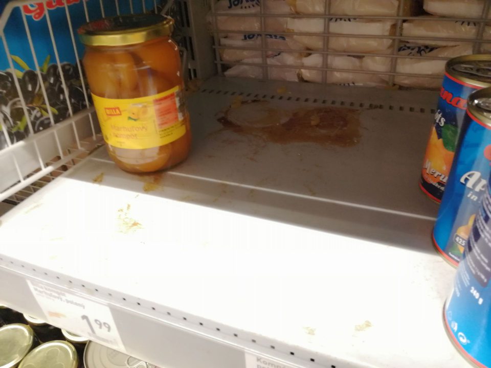 Znečistená polica regálu na predajnej ploche.