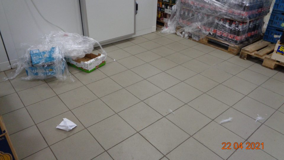 V sklade potravín na viacerých miestach znečistená podlaha, rozhádzané papiere, kartóny, igelity, handry a chuchvalce prachu.
