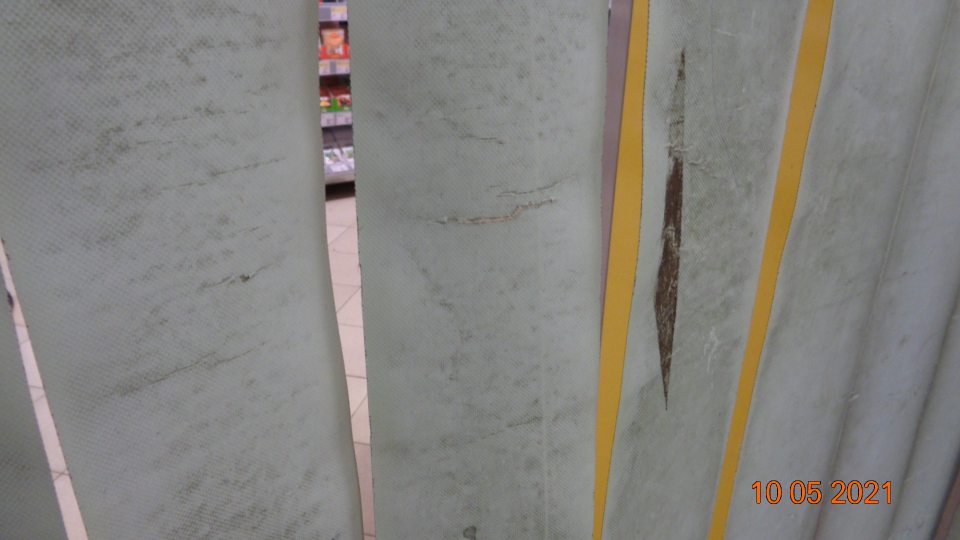 Plastové závesy deliace sklad od predajnej plochy znečistené hrubou špinou.