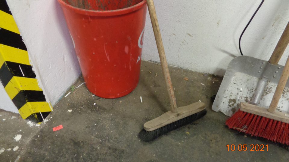 Okolie smetného koša znečistené ohorkami cigariet, špinou a prachom.