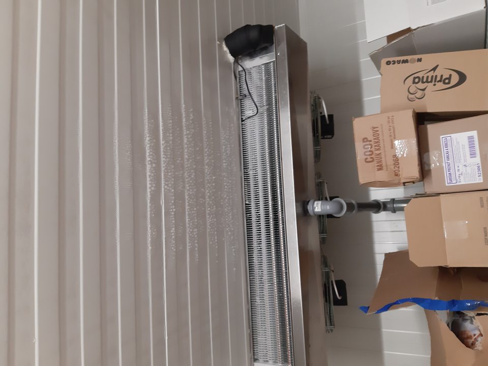 V mraziacom boxe v sklade námraza na mraziacej jednote, kondenzát na strope nad mraziacou jednotkou.