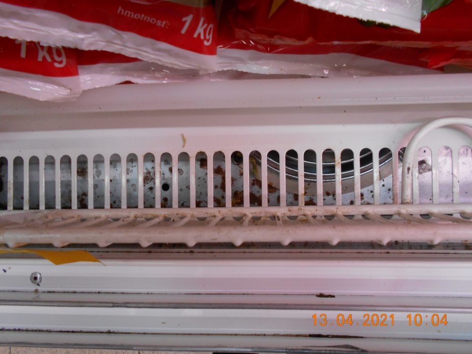 Znečistené chladiarenské vitríny s uchovávanými mliečnymi výrobkami a čerstvou chladenou zeleninou v ťažko prístupných miestacch - pod mriežkou. 