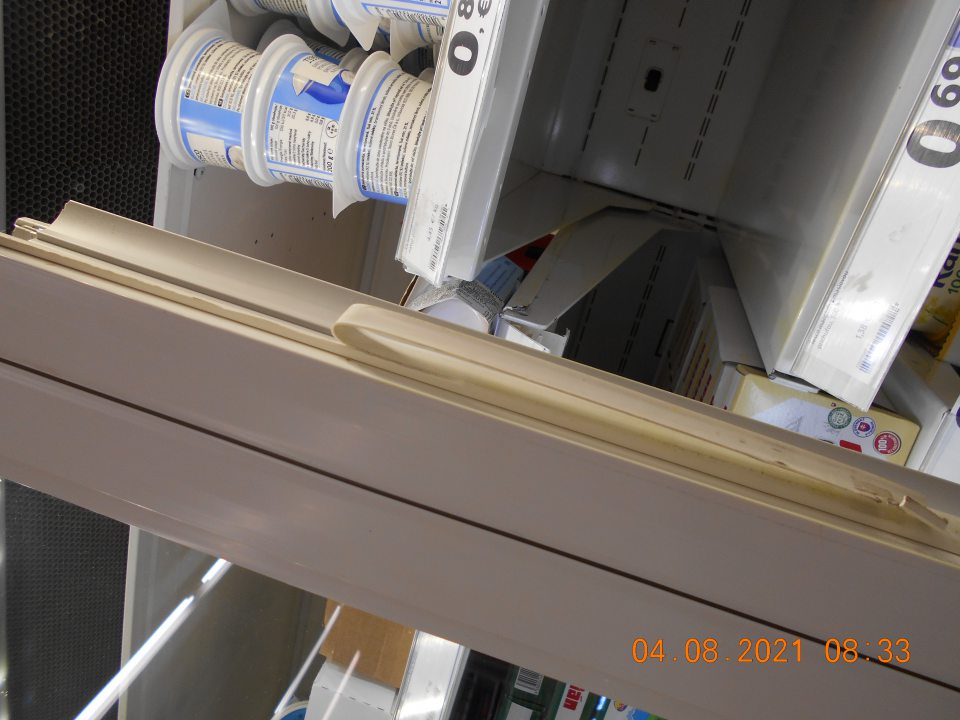  Poškodené tesnenie na posuvných dvierkach chladiarenskej vitríny s uchovávanými mliečnymi výrobkami.