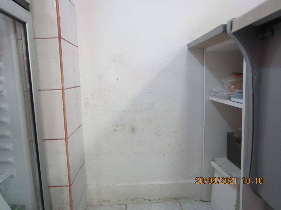 Zistená poškodená a znečistená stena pri mäsovom kútiku a vedľa chladiarenskej vitríny s mliečnymi výrobkami.