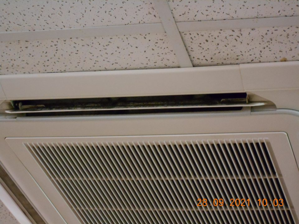 Znečistená klimatizačná jednotka na predajnej ploche nad regálmi so suchými potravinami.