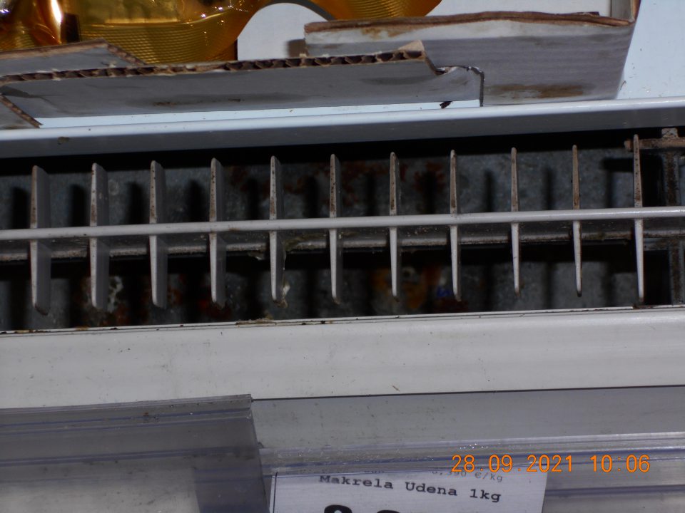 Znečistené chladiarenské zariadenie pod mriežkou v ťažko dostupných miestach, s výskytom korózie.