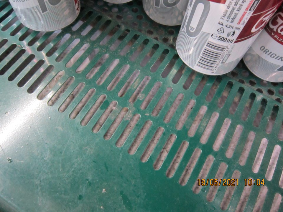 Chladiace zariadenie na predajnej ploche – vitrína Pilsner Urquell na uchovávanie nápojov (plechovkových pív) - znečistené dno pod mriežkou,  zaschnuté nánosy špiny, papieriky, uhynutý hmyz. 