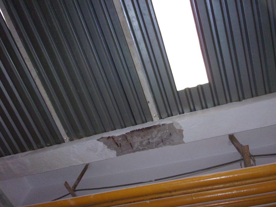 Poškodená hygienická maľba stropu pri vstupe do výrobných priestorov.