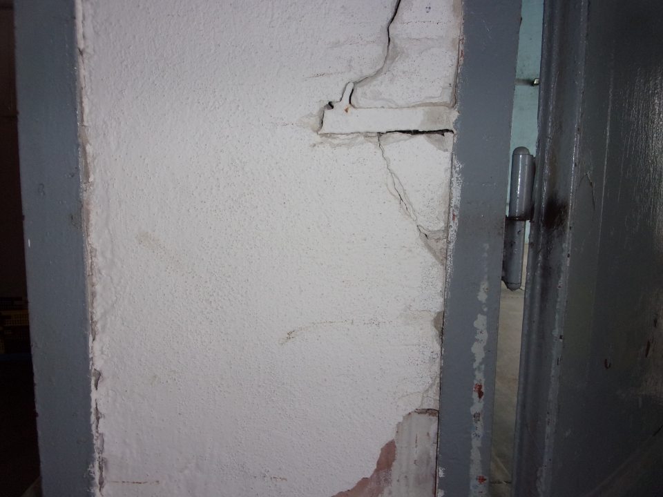 Poškodená hygienická maľba pri dverách na expedícii.