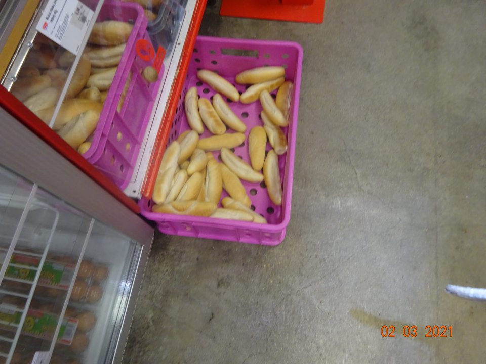 Prepravka s nebalenými rožkami priamo na podlahe na predajni.