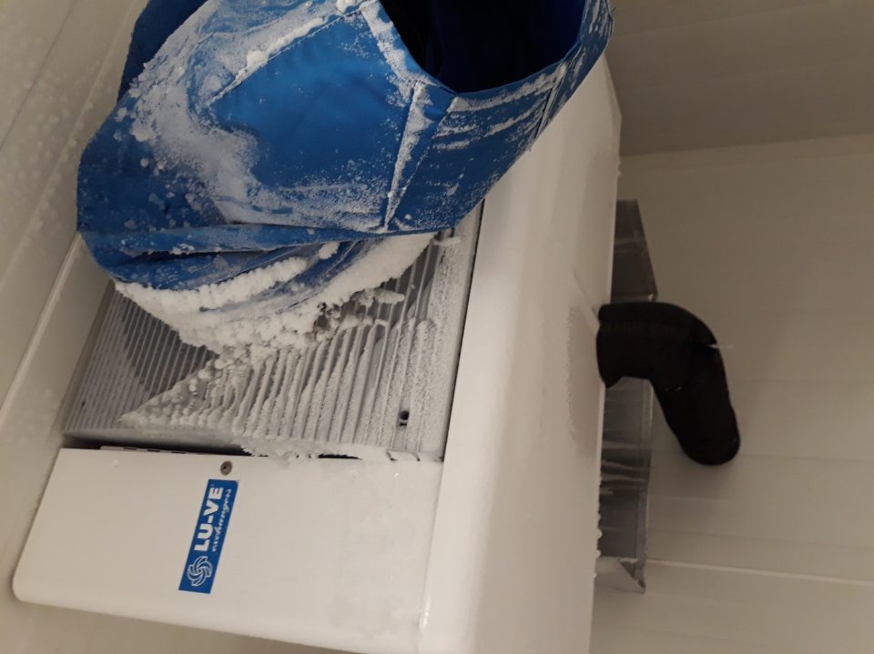 hrubá vrstva namrznutého ľadového povlaku na mraziacej jednotke v mraziacom boxe na hlbokozmrazené pekárske polotovary