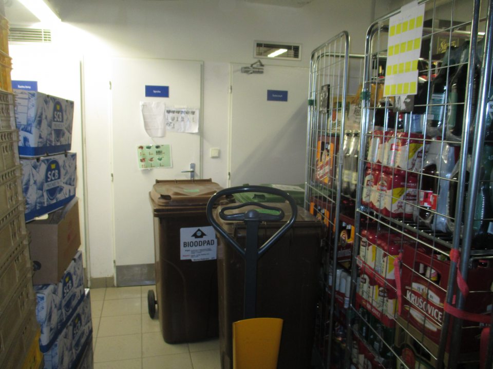 Manipulačná chodba v sklade: preplnená tovarom, vratné obalov/PVC prepraviek pri príjmových dverách, neoddelené PVC kontajnery určené pre VŽP, zablokovaný prístup k príručnému umývadlu v sklade, nie sú vytvorené uličky, nie je zabezpečené riadne oddelenie nezlúčiteľných druhov tovaru, neumožnenie dôkladného čistenia a sanitácie.