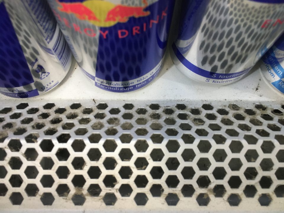 mechanické nečistoty (prach) zo zanesenej spodnej perforovanej mriežky vo vitríne s nápojom Redbull