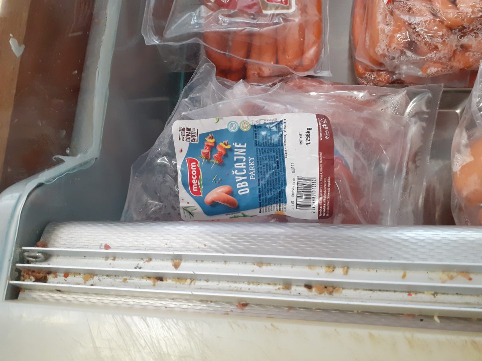 Lišty na chladiarenskom zariadení s mäsovými výrobkami znečistené zvyškami potravín.