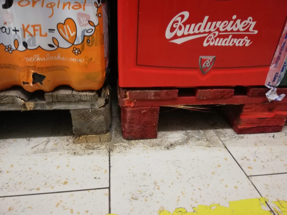 Podlahy v skladovacích priestoroch, priestory medzi paletami a pod paletami silno znečistené čiernymi nečistotami, výskytom zvyškov potravín a obalového materiálu.