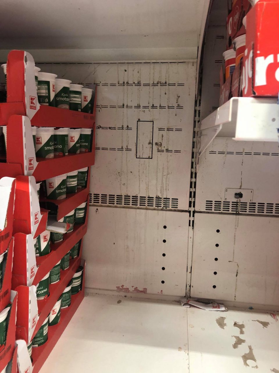 Znečistená chladiaca vitrína pri predaji mliečnych výrobkov. 