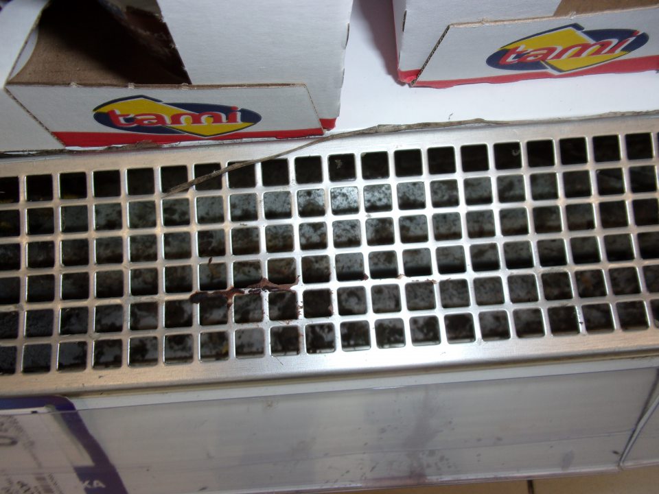 Znečistené mriežky a priestor pod nimi v chladničkách.