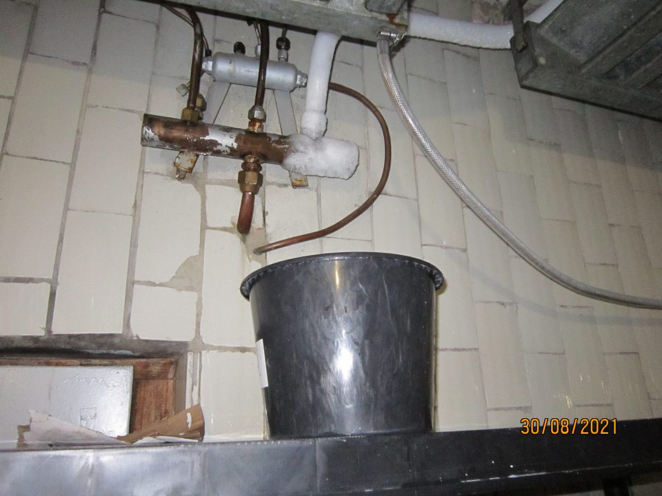 Kondenz v chladiacom boxe na mliečne výrobky voľne stekajúci do nekrytého vedra.