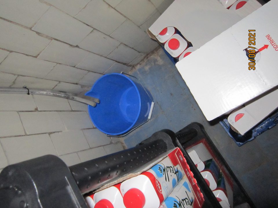 ondenz kvapkajúci z chladiarenskej jednotky v chladiacom boxe na mliečne výrobky zachytávaný do nekrytého vedra.