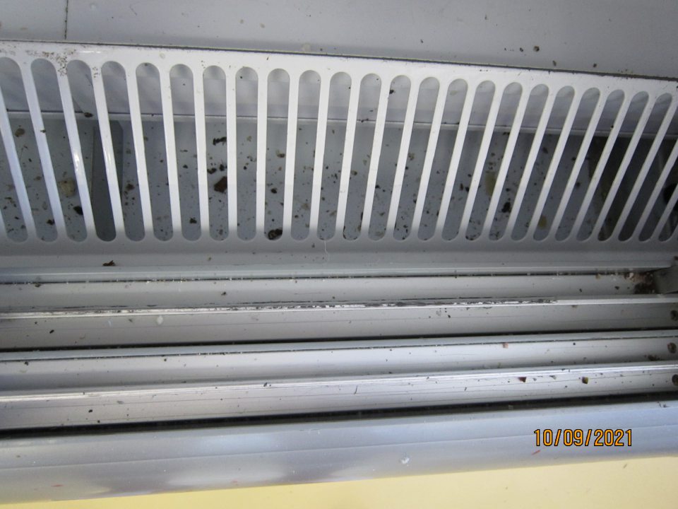 Chladiace zariadenia za obslužným pultom na predaj porciovaných mliečnych a mäsových výrobkov -znečistený priestor pod mriežkami, vodiace drážky a spodné časti zariadení.