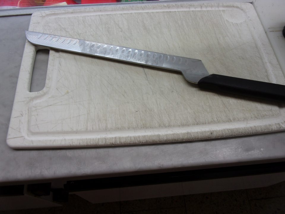Opotrebovaná doska na krájanie v mäsovom pulte.