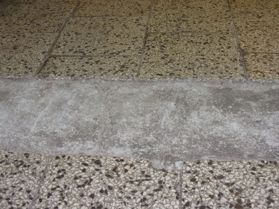 Poškodená podlaha v sklade potravín, v ktorej sa zhromažďujú nečistoty.