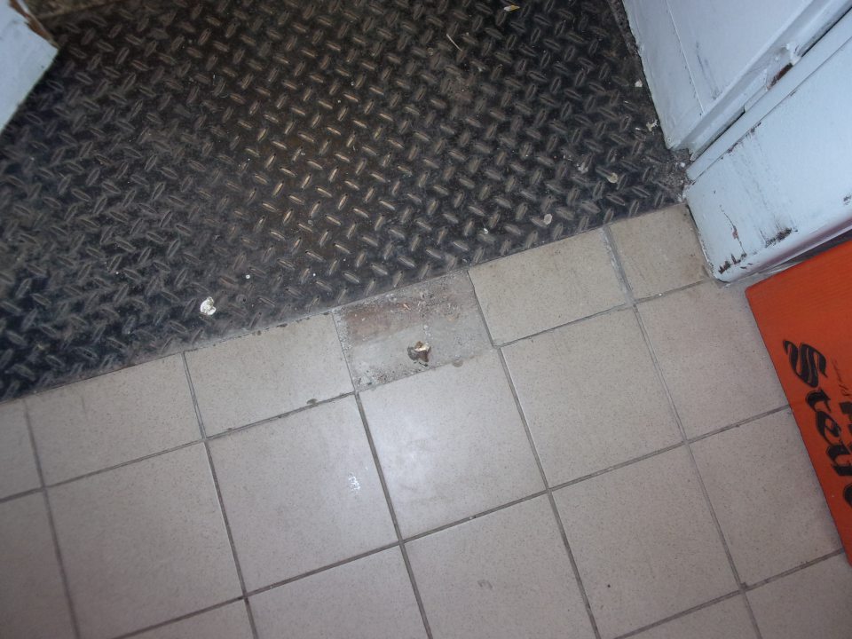 Poškodená podlaha v sklade potravín.