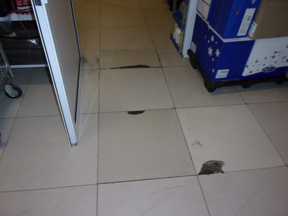 Poškodená podlaha v sklade potravín.