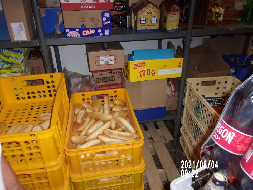 prepravky s nebalenými pekárskymi výrobkami uložené v sklade na drevenej palete, neprekryté