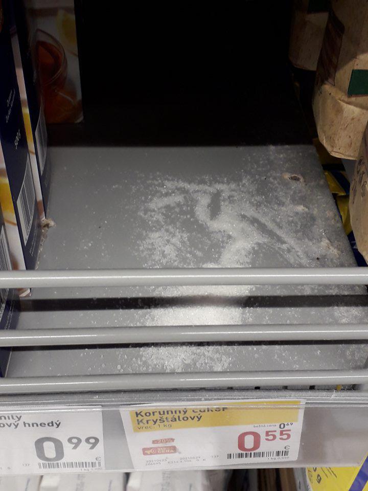 Znečistený regál rozsypaným tovarom na predajni